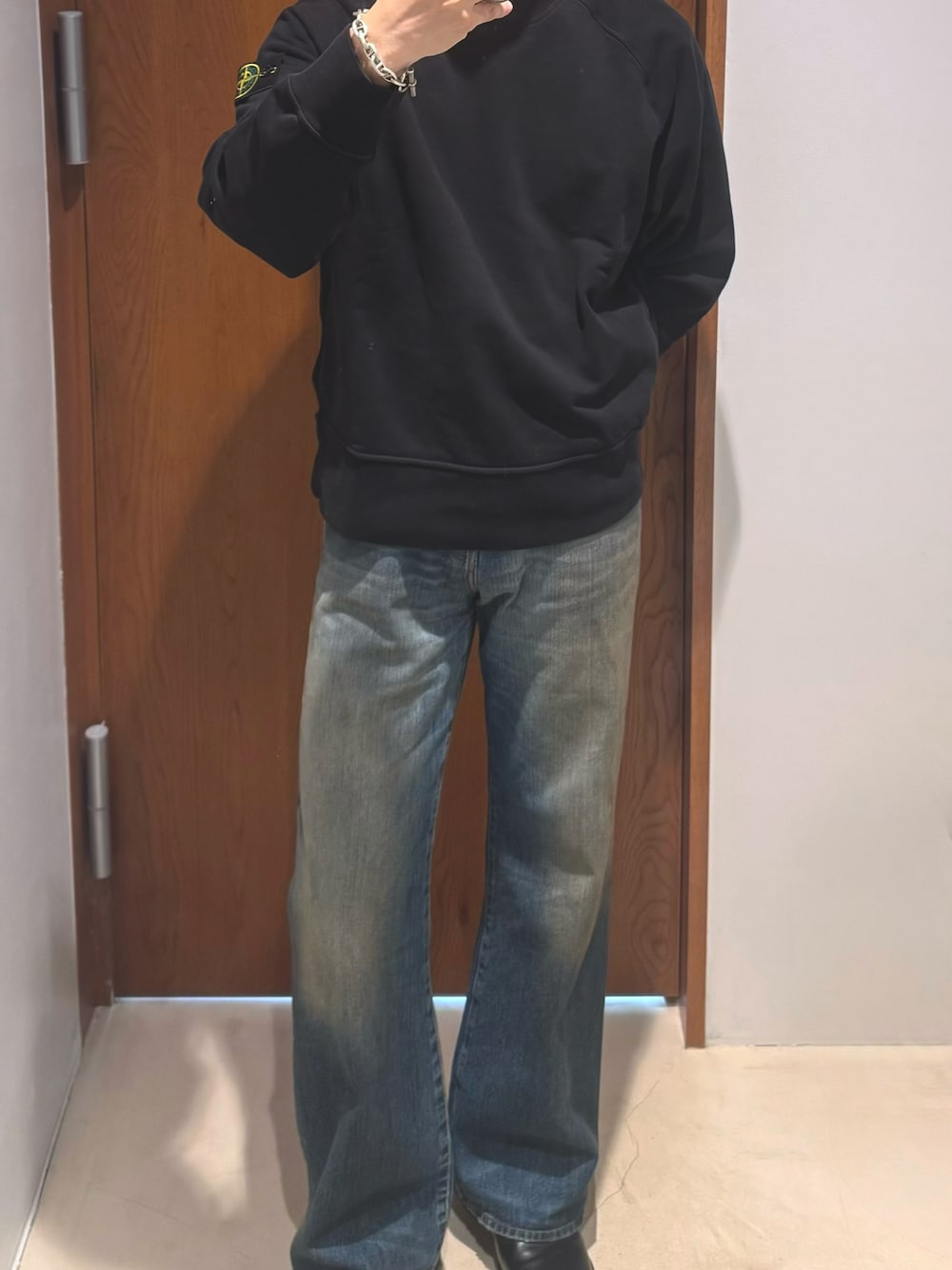 ブラック系のドレスシューズ、ブルー系のデニムパンツ、ブラック系のスウェットを着用したメンズの秋コーディネートの1枚目の写真