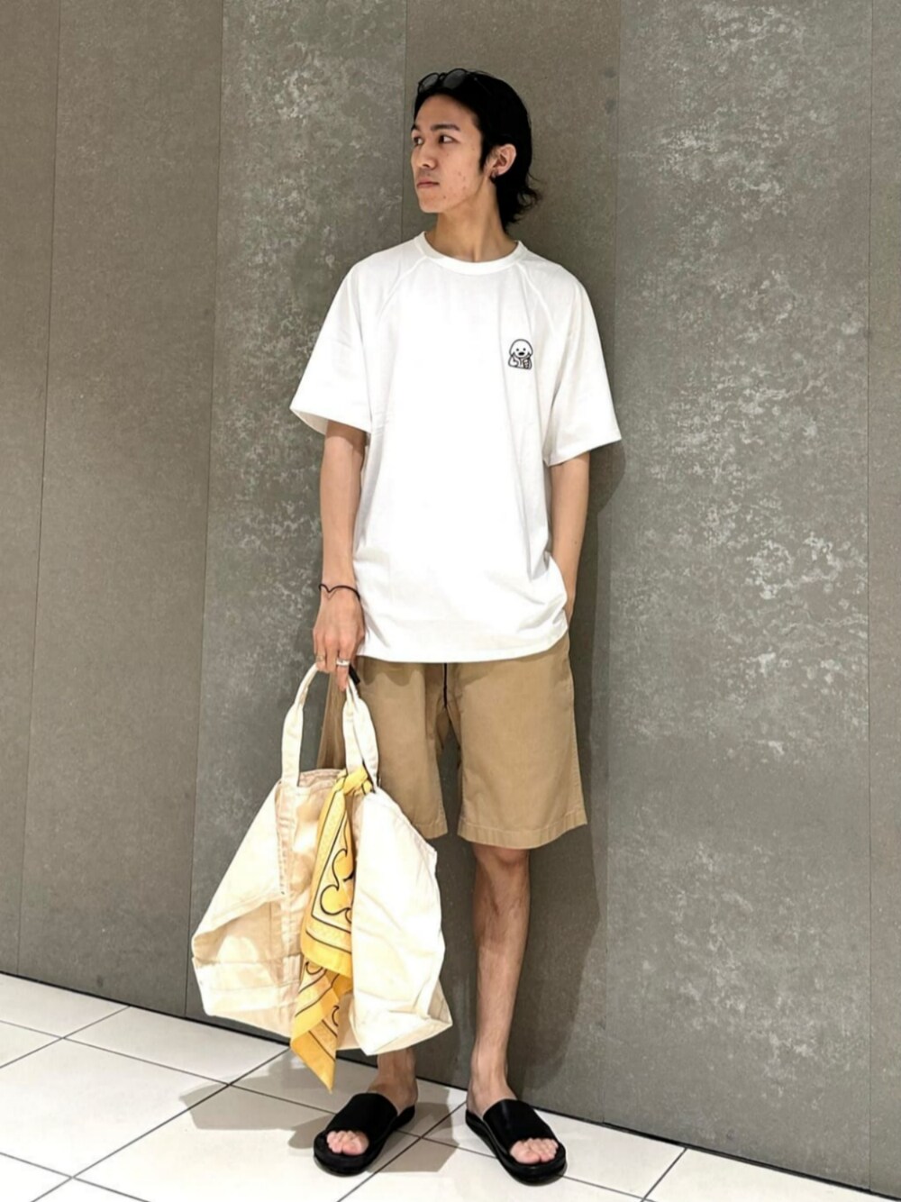 ホワイト系のTシャツ/カットソー、ベージュ系のその他パンツ、ブラック系のサンダルを着用したメンズの春コーディネートの1枚目の写真