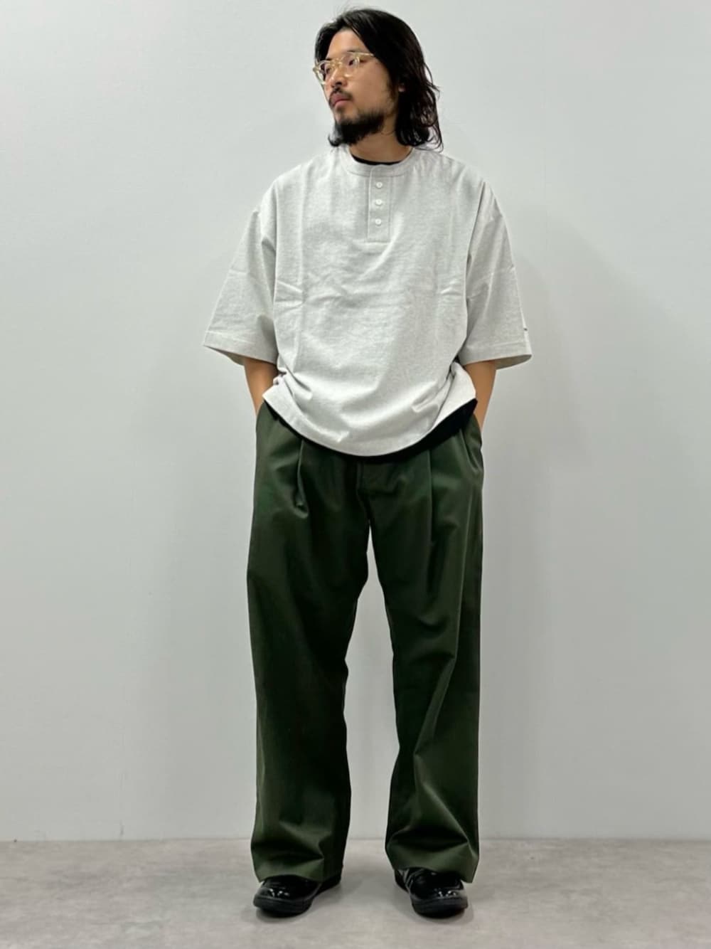 グレー系のTシャツ/カットソー、グリーン系のスラックスを着用したメンズの春コーディネートの1枚目の写真