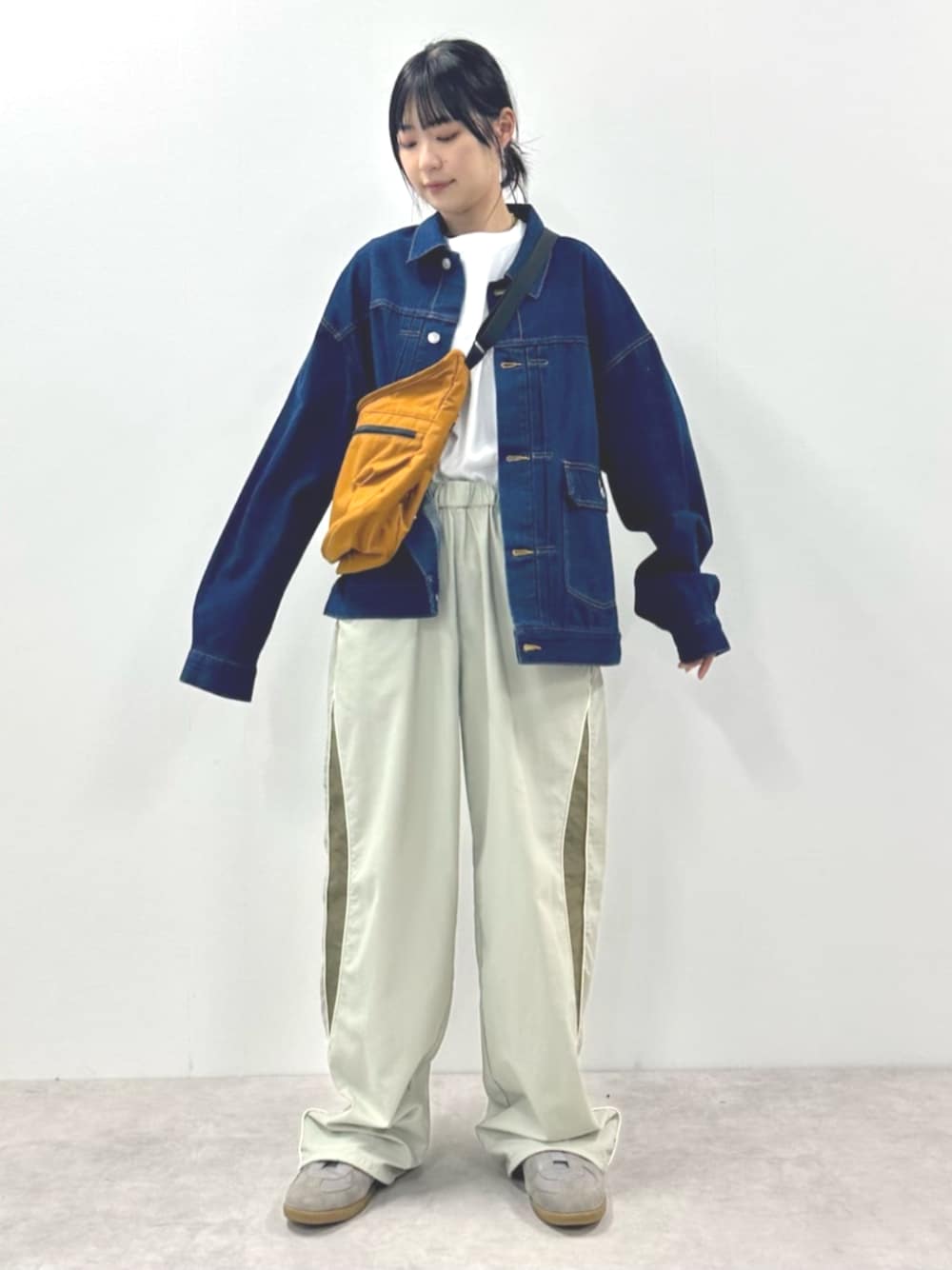 ブルー系のデニムジャケット、ホワイト系のTシャツ/カットソー、ブラウン系のショルダーバッグを着用したレディースの春コーディネートの1枚目の写真