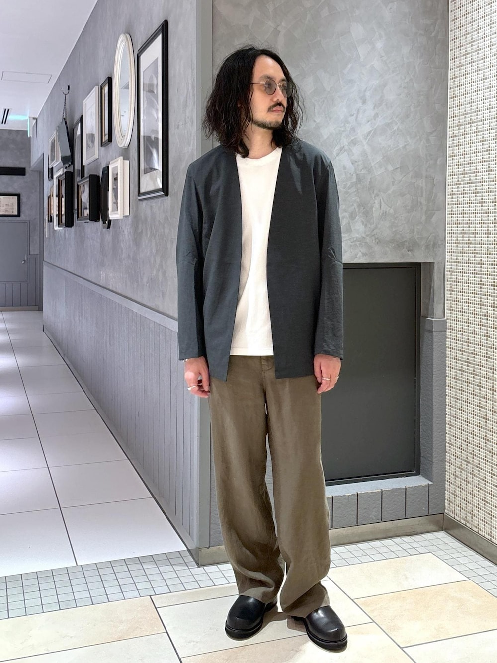 グリーン系のセットアップ、ホワイト系のTシャツ/カットソー、グリーン系のスラックスを着用したメンズの春コーディネートの1枚目の写真