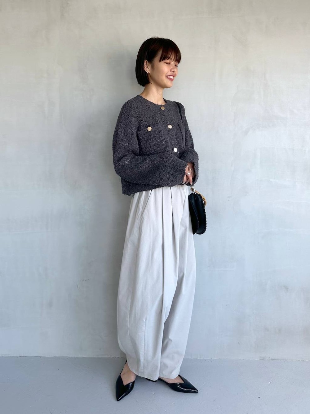 ブラック系のパンプス、グレー系のその他パンツ、グレー系のカーディガン/ボレロを着用したレディースの冬コーディネートの1枚目の写真