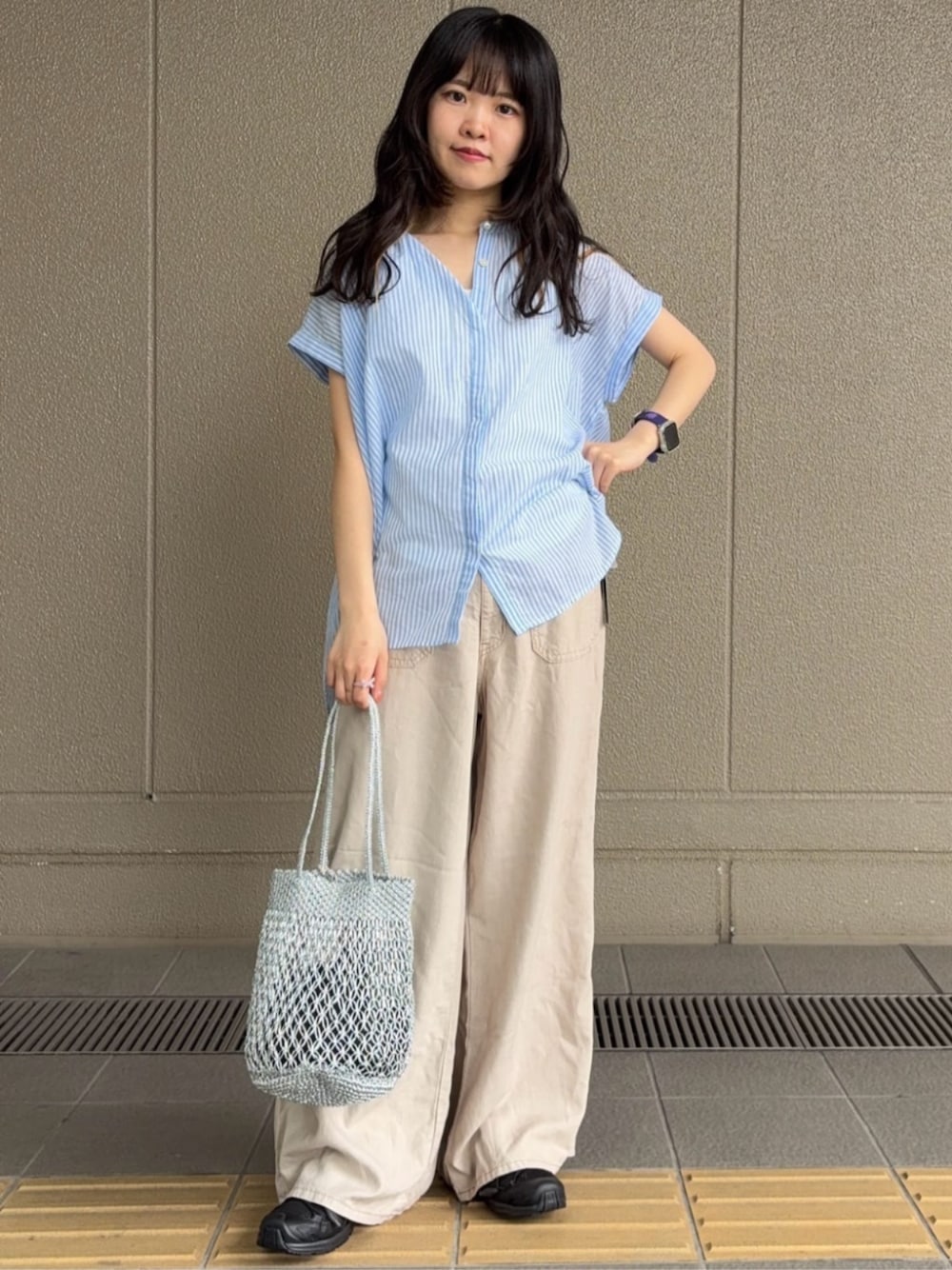 ベージュ系のデニムパンツ、シルバー系のハンドバッグ、ブルー系のシャツ/ブラウスを着用したレディースの夏コーディネートの1枚目の写真