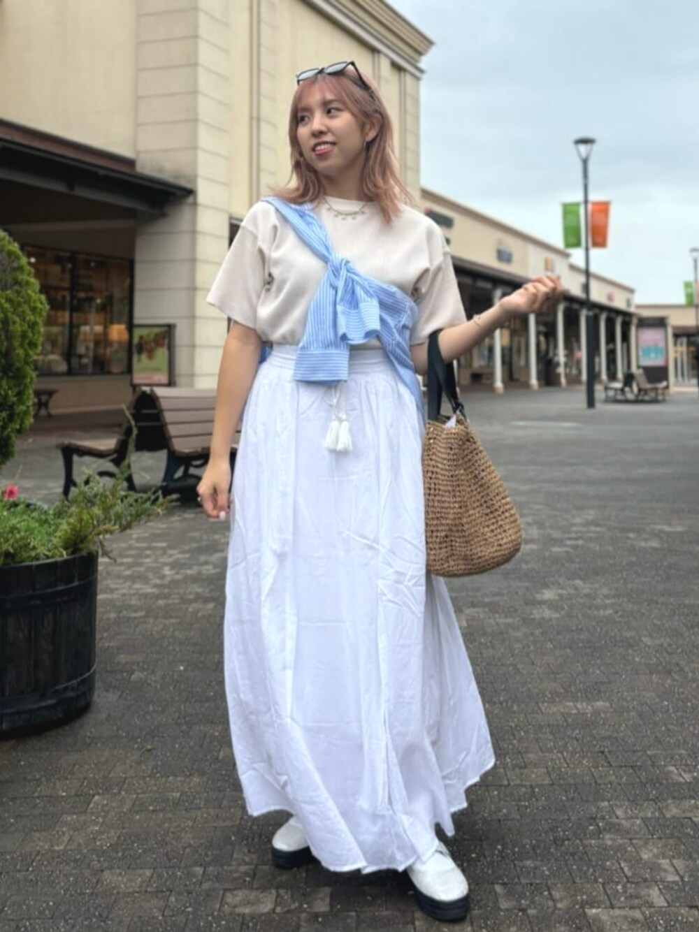 ベージュ系のTシャツ/カットソー、ホワイト系のスカート、ブルー系のシャツ/ブラウスを着用したレディースの春コーディネートの1枚目の写真