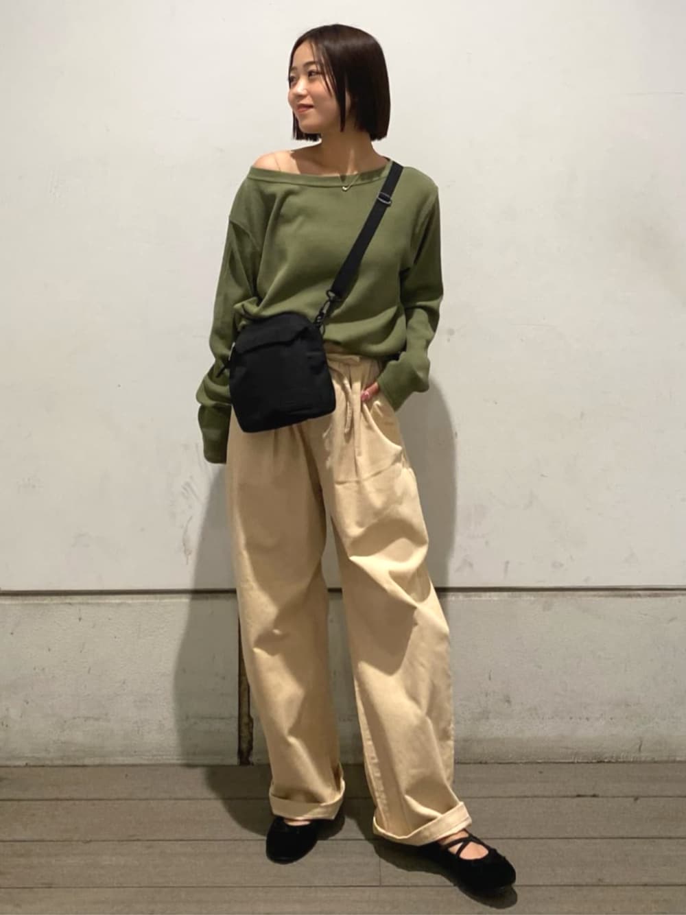 ベージュ系のその他パンツ、グリーン系のTシャツ/カットソー、ブラウン系のバレエシューズを着用したレディースの秋コーディネートの1枚目の写真