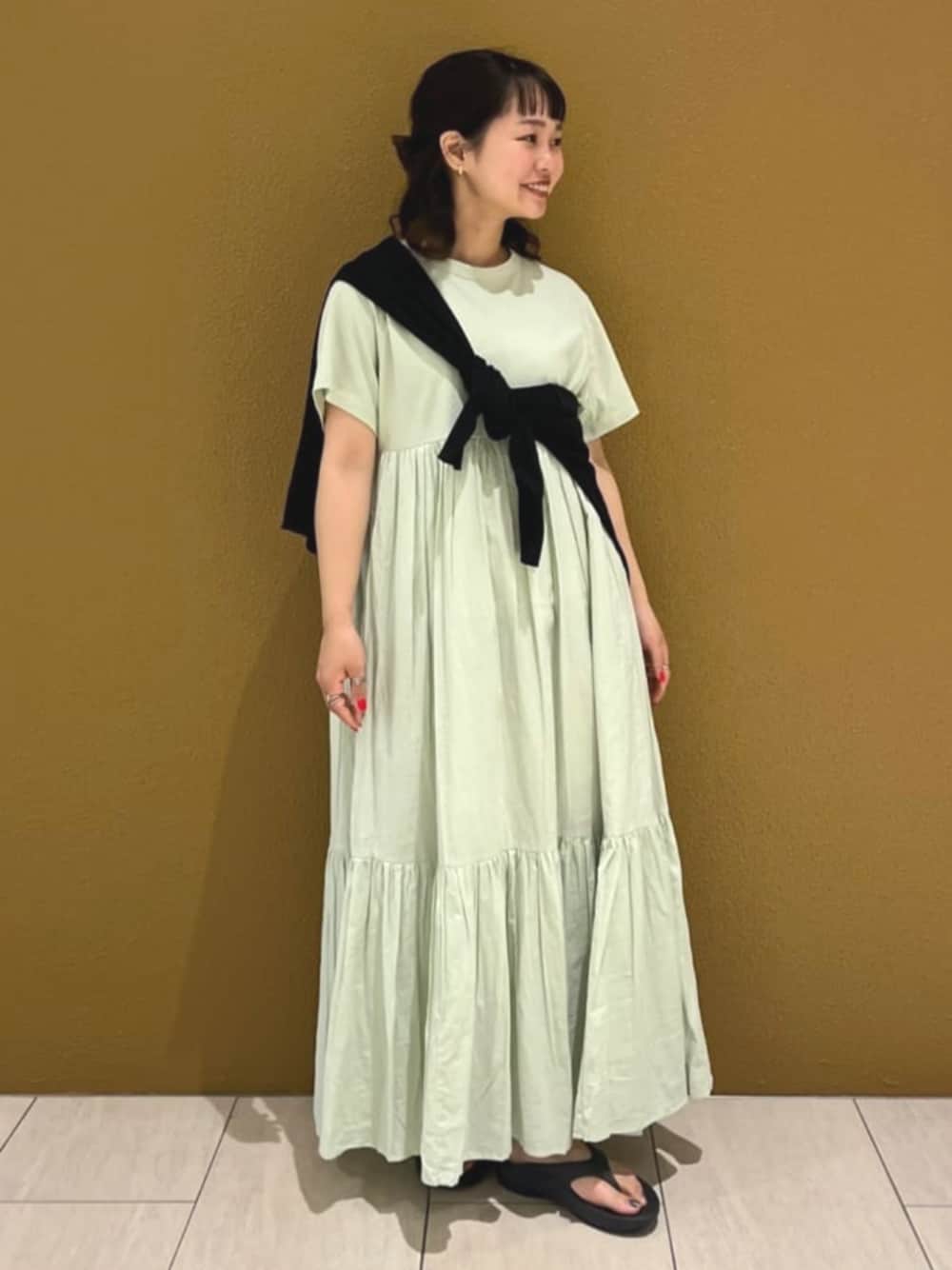ブルー系のワンピース、ブラック系のニット/セーター、ブラック系のサンダルを着用したレディースの春コーディネートの1枚目の写真