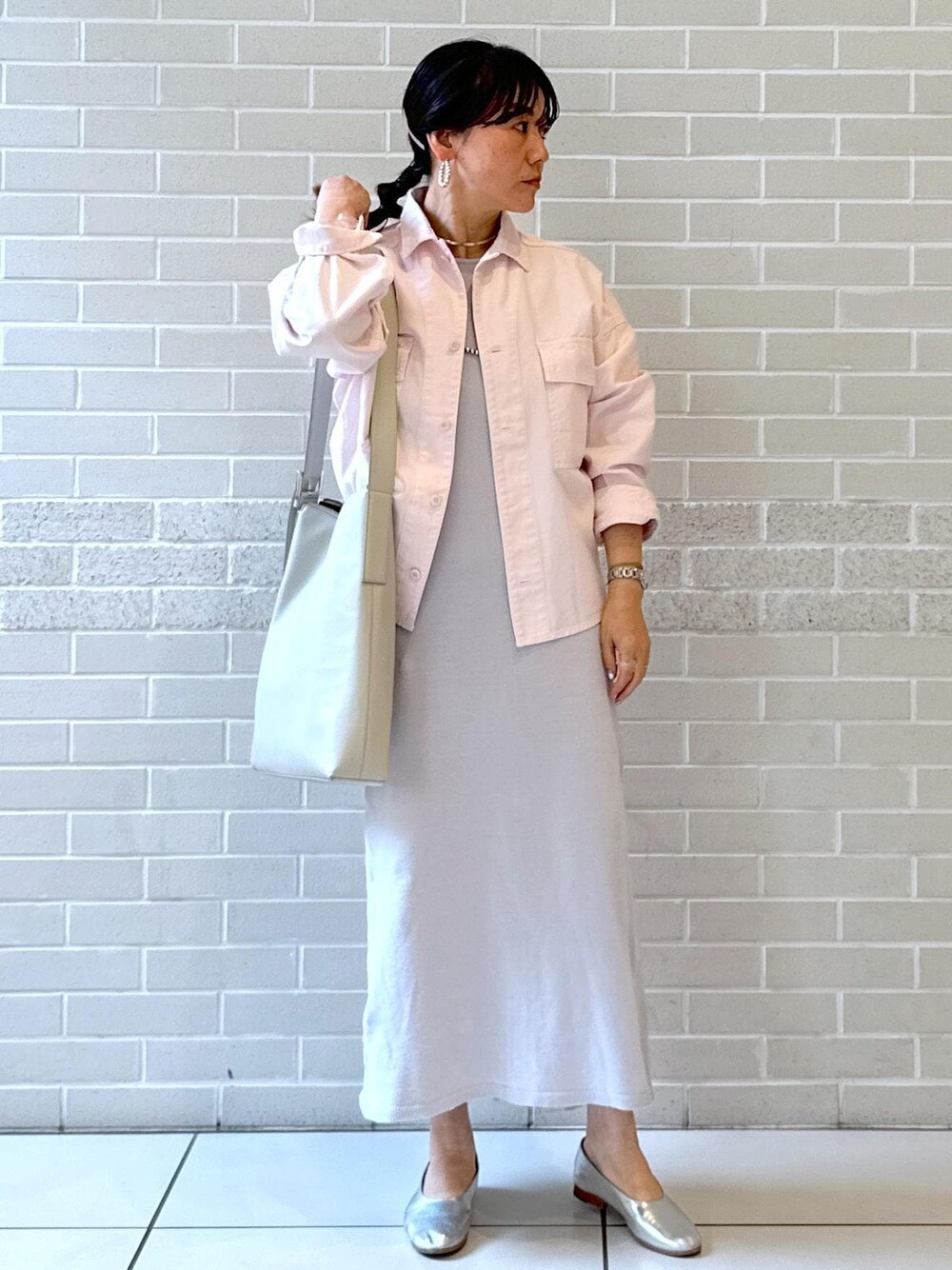 シルバー系のパンプス、グレー系のワンピース、グレー系のショルダーバッグを着用したレディースの冬コーディネートの1枚目の写真