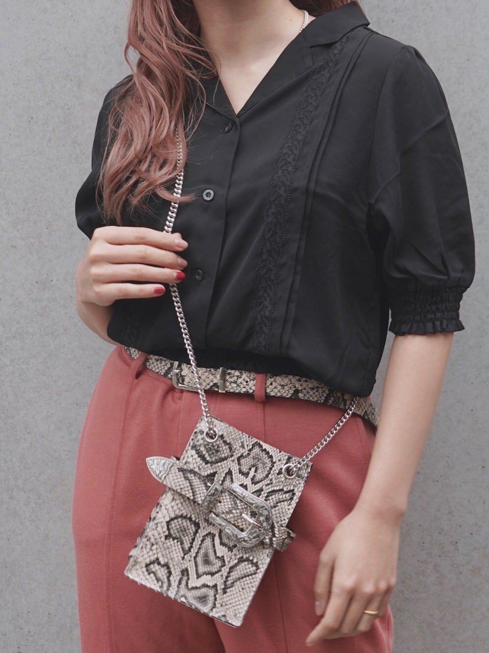 ブラック系のシャツ/ブラウス、オレンジ系のパンツ、ベージュ系のバッグを着用したレディースの冬コーディネートの1枚目の写真