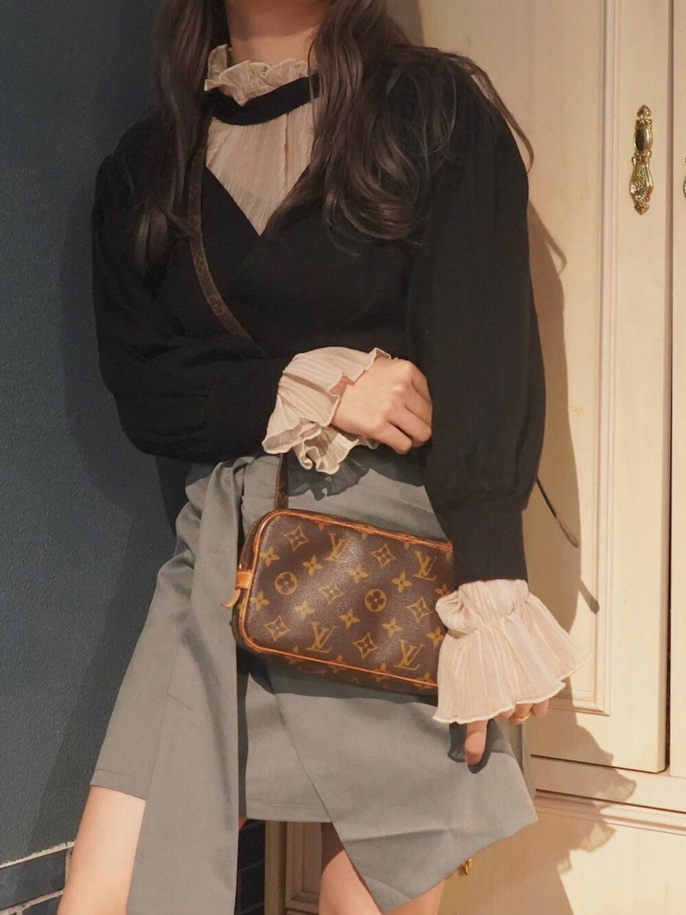 ブラック系のニット/セーター、グレー系のスカート、ホワイト系のその他を着用したレディースの秋コーディネートの1枚目の写真