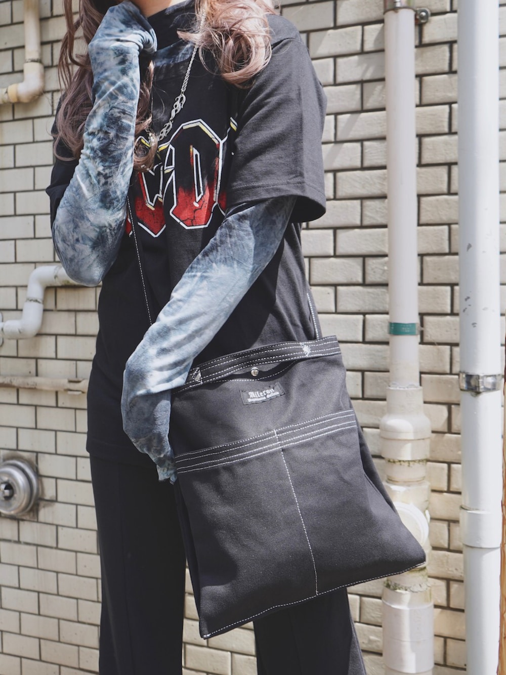 ブラック系のショルダーバッグ、ブラック系のTシャツ/カットソー、ブラック系のTシャツ/カットソーを着用したレディースの春コーディネートの1枚目の写真