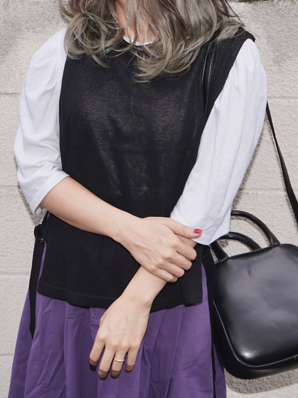 ブラック系のベスト、ホワイト系のTシャツ/カットソー、パープル系のスカートを着用したレディースの冬コーディネートの1枚目の写真