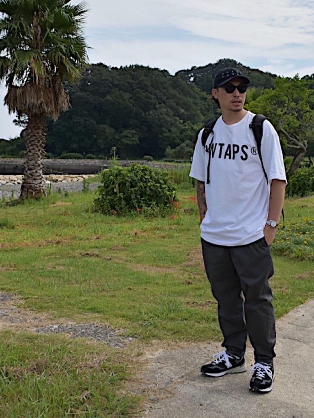 ブラック系のスニーカー、ホワイト系のTシャツ/カットソーを着用したメンズの秋コーディネートの1枚目の写真