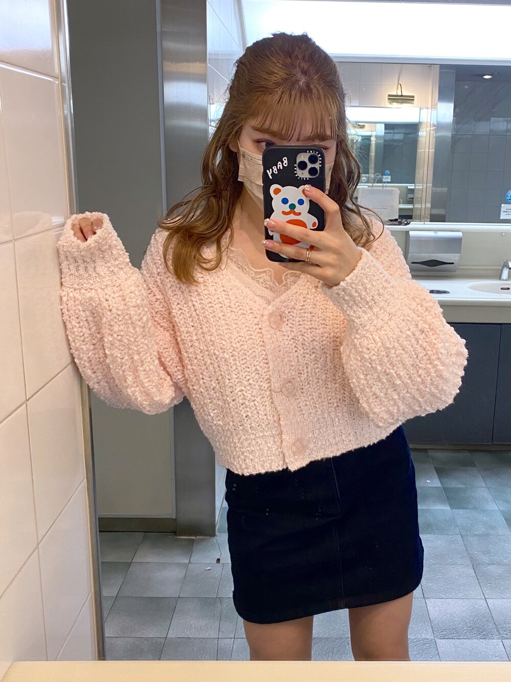 ピンク系のカーディガン/ボレロ、ブルー系のデニムスカートを着用したレディースの冬コーディネートの1枚目の写真