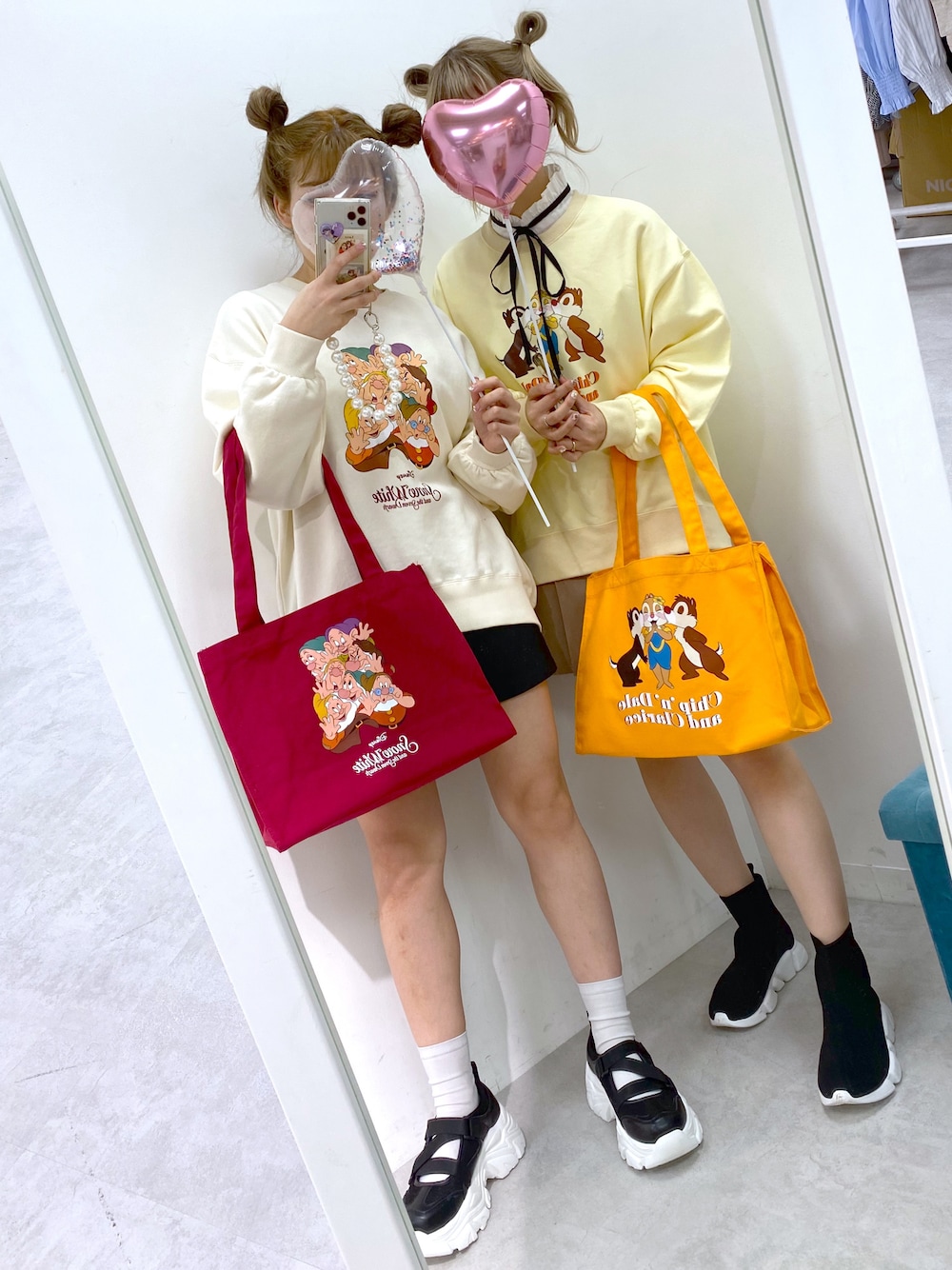 イエロー系のスウェット、レッド系のトートバッグを着用したレディースの冬コーディネートの1枚目の写真