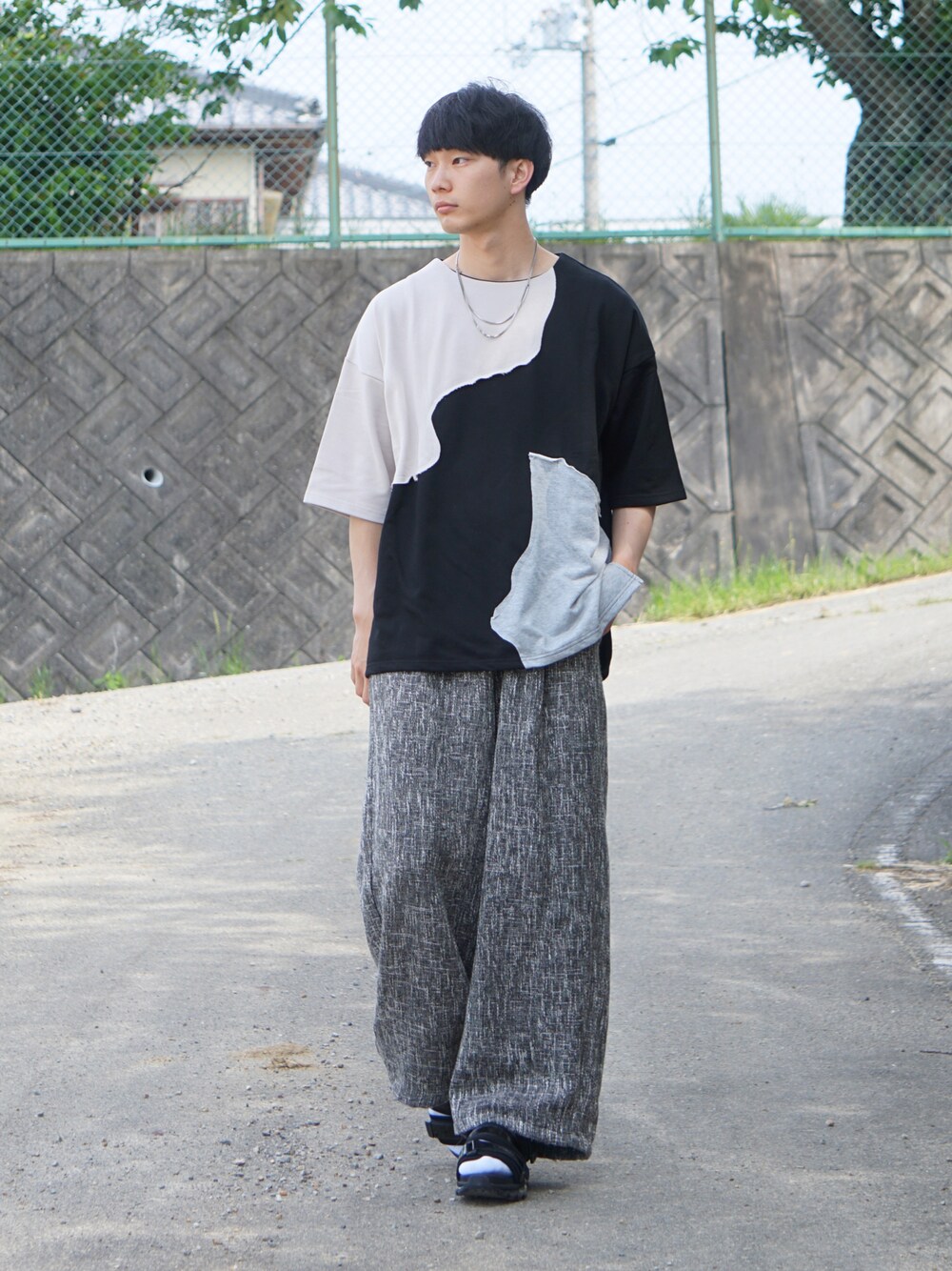 ブラック系のTシャツ/カットソー、ブラック系のその他パンツ、ホワイト系のサンダルを着用したメンズの夏コーディネートの1枚目の写真