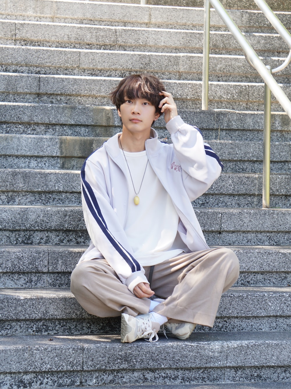 ホワイト系のジャケット/アウター、ホワイト系のTシャツ/カットソー、ベージュ系のスラックスを着用したメンズの秋コーディネートの1枚目の写真