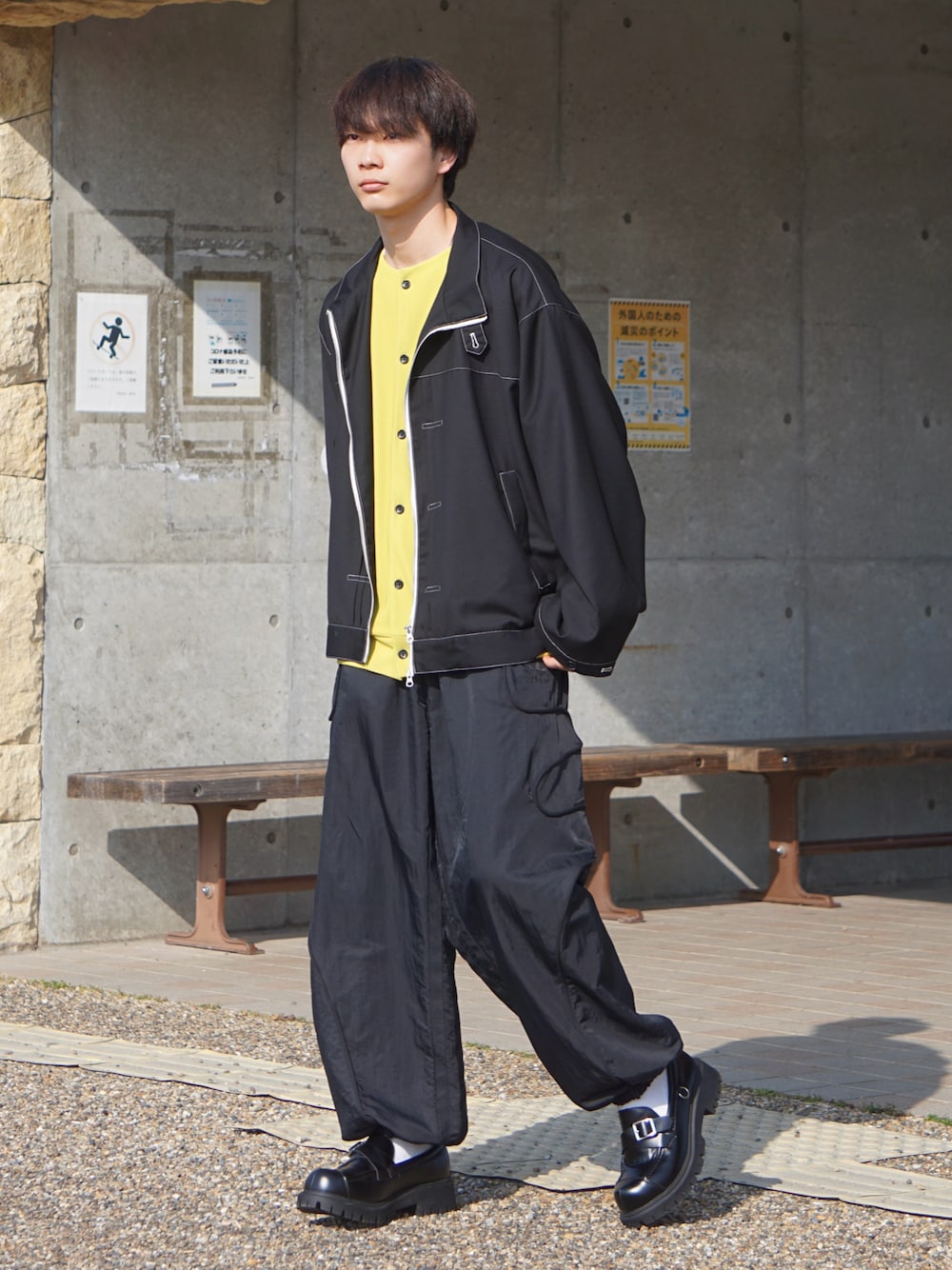ブラック系のブルゾン、イエロー系のカーディガン/ボレロ、ブラック系のパンツを着用したメンズの春コーディネートの1枚目の写真