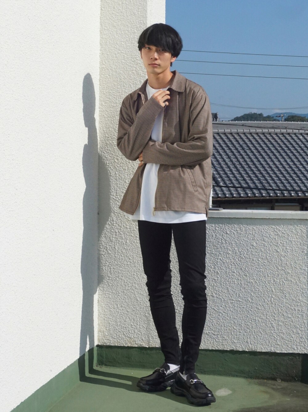 ホワイト系のTシャツ/カットソー、ブラック系のデニムパンツ、ブラック系のスニーカーを着用したメンズの秋コーディネートの1枚目の写真
