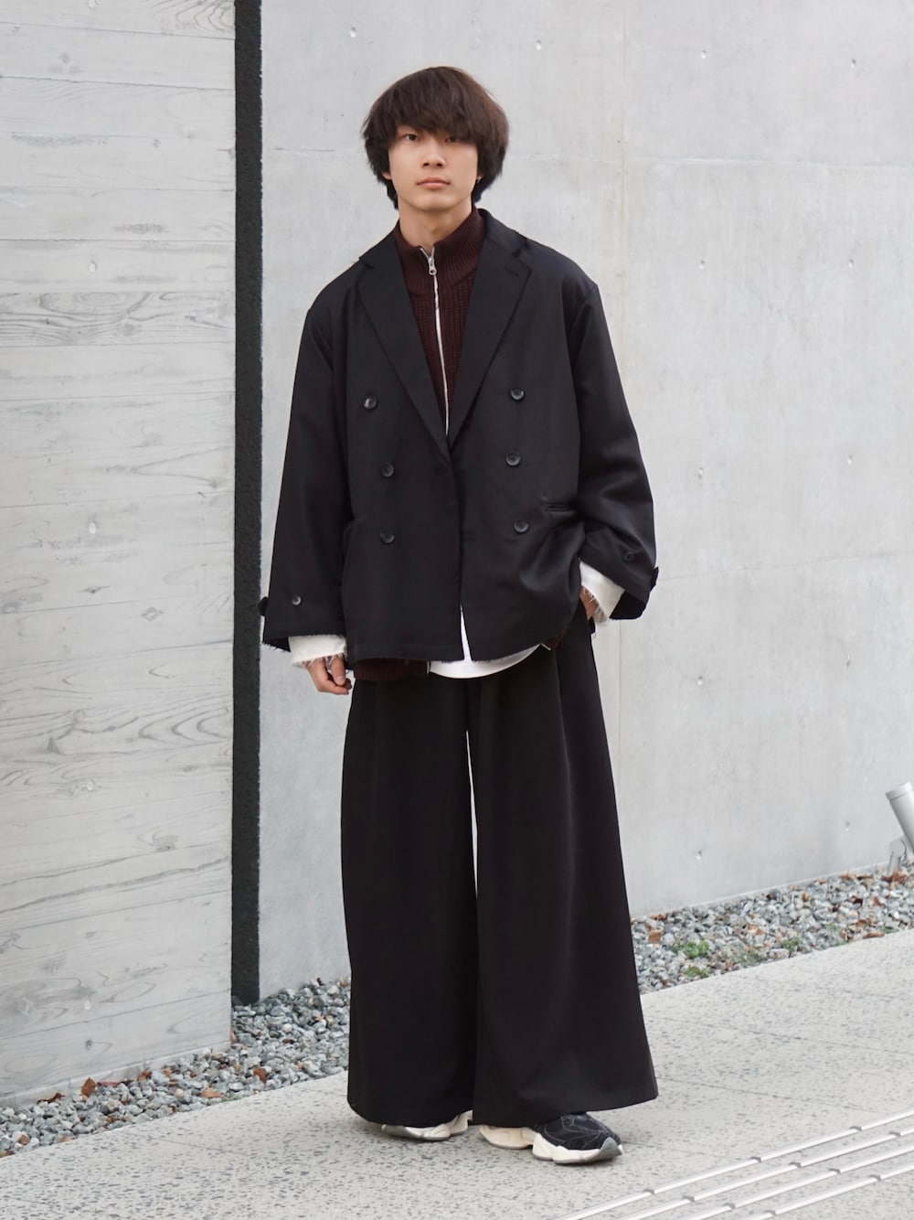 ブラック系のスラックス、ブラック系のテーラードジャケット、ブラウン系のカーディガン/ボレロを着用したメンズの冬コーディネートの1枚目の写真