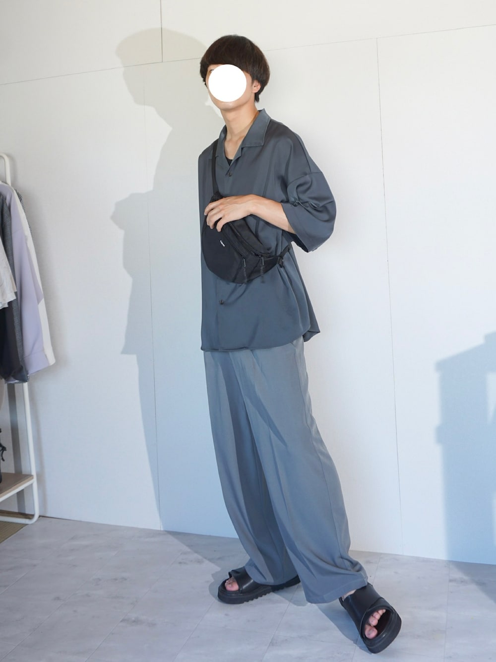 ブルー系のスラックス、グレー系のシャツ/ブラウス、ブラック系のサンダルを着用したメンズの夏コーディネートの1枚目の写真