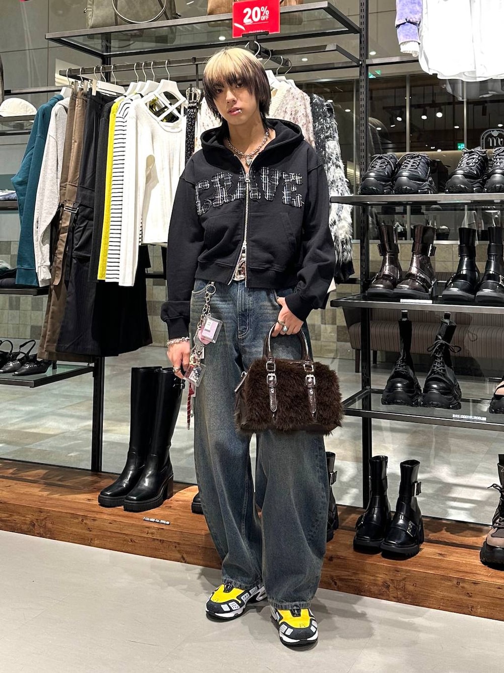 ブラウン系のボストンバッグ、ブルー系のデニムパンツ、ブラック系のパーカーを着用したメンズの冬コーディネートの1枚目の写真