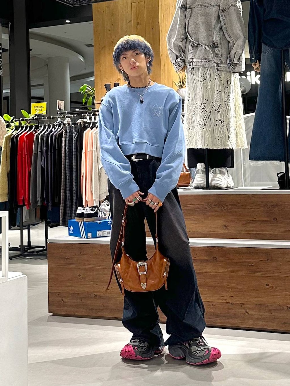 ブルー系のデニムパンツ、ブルー系のスウェット、ブラウン系のショルダーバッグを着用したメンズの春コーディネートの1枚目の写真
