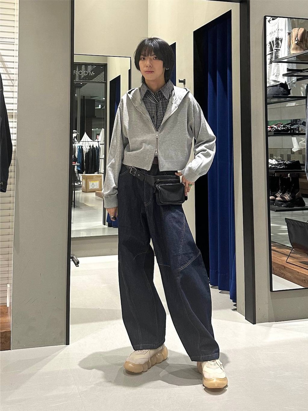 グレー系のパーカー、ブルー系のデニムパンツ、ブラック系のボディバッグ/ウエストポーチを着用したメンズの秋コーディネートの1枚目の写真