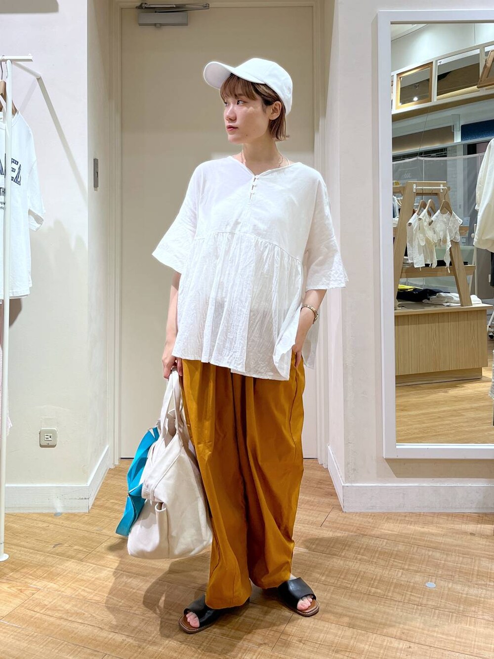 ブラック系のサンダル、イエロー系のその他パンツ、ホワイト系のTシャツ/カットソーを着用したレディースの夏コーディネートの1枚目の写真