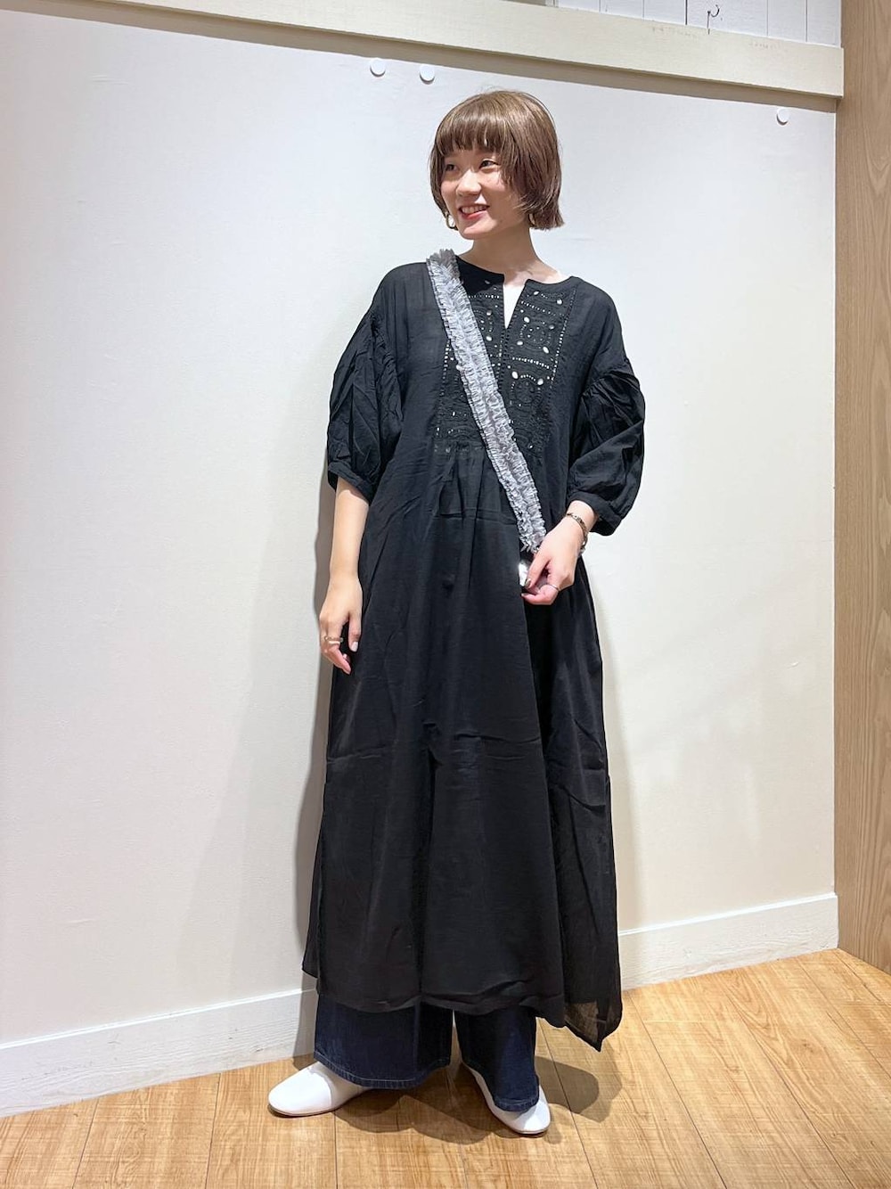 ホワイト系のパンプス、ブラック系のワンピース、グレー系のスマホグッズを着用したレディースの秋コーディネートの1枚目の写真