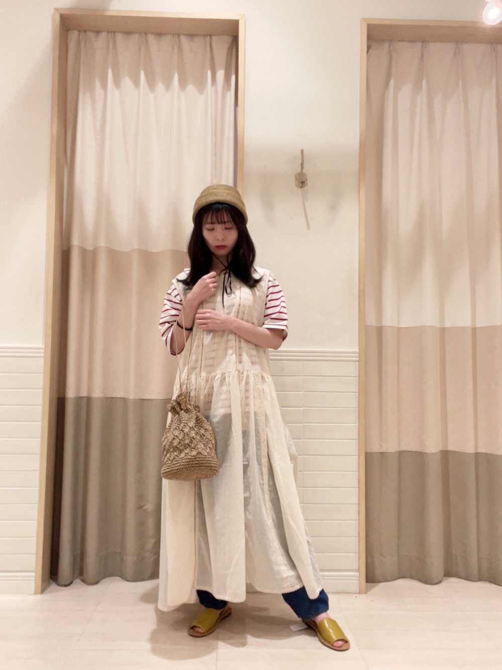 イエロー系のサンダル、ベージュ系のエコバッグ/サブバッグ、レッド系のトップスを着用したレディースの夏コーディネートの1枚目の写真