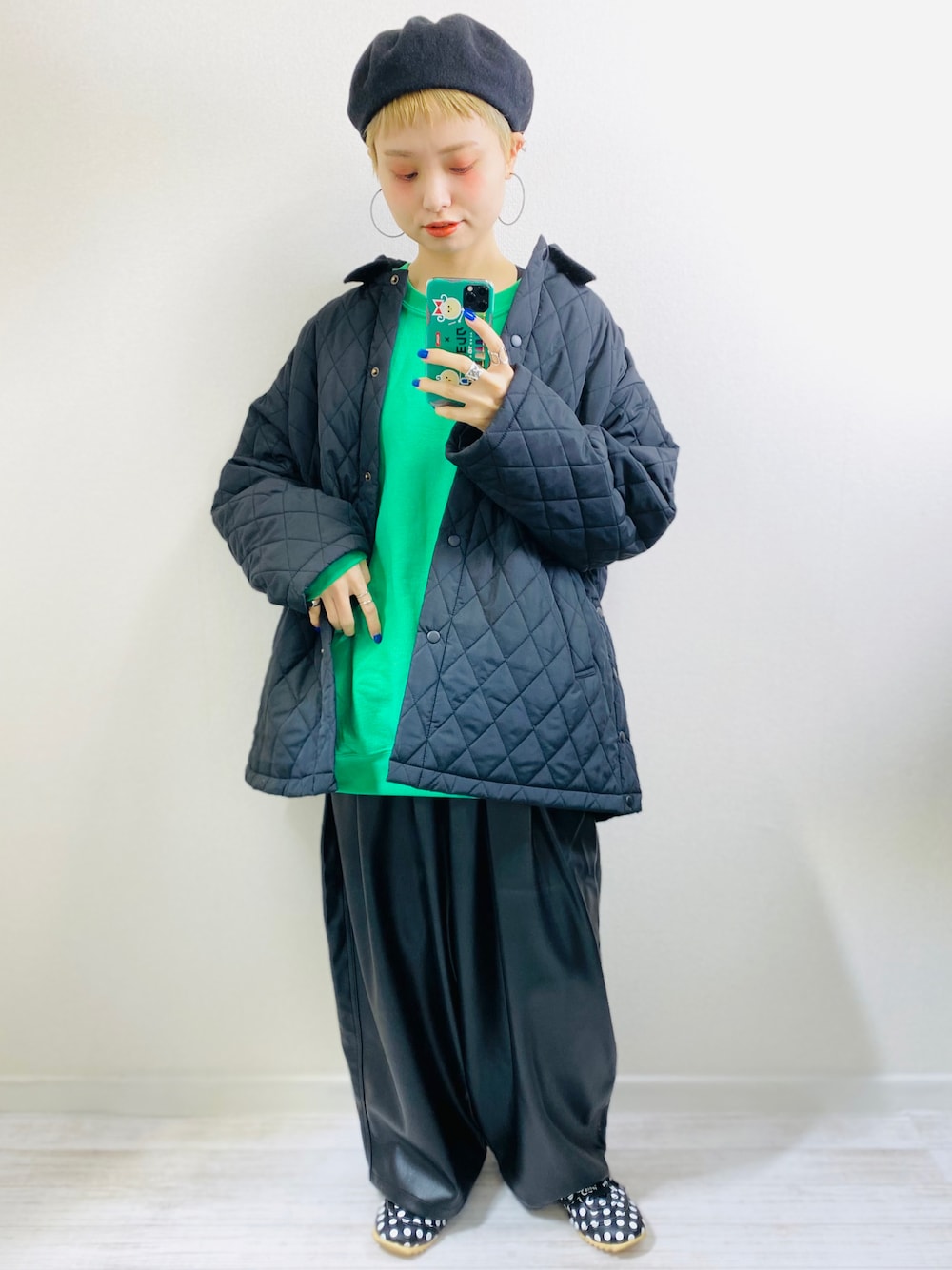 グリーン系のスウェット、ブラック系のブルゾン、ブラック系のスニーカーを着用したレディースの秋コーディネートの1枚目の写真