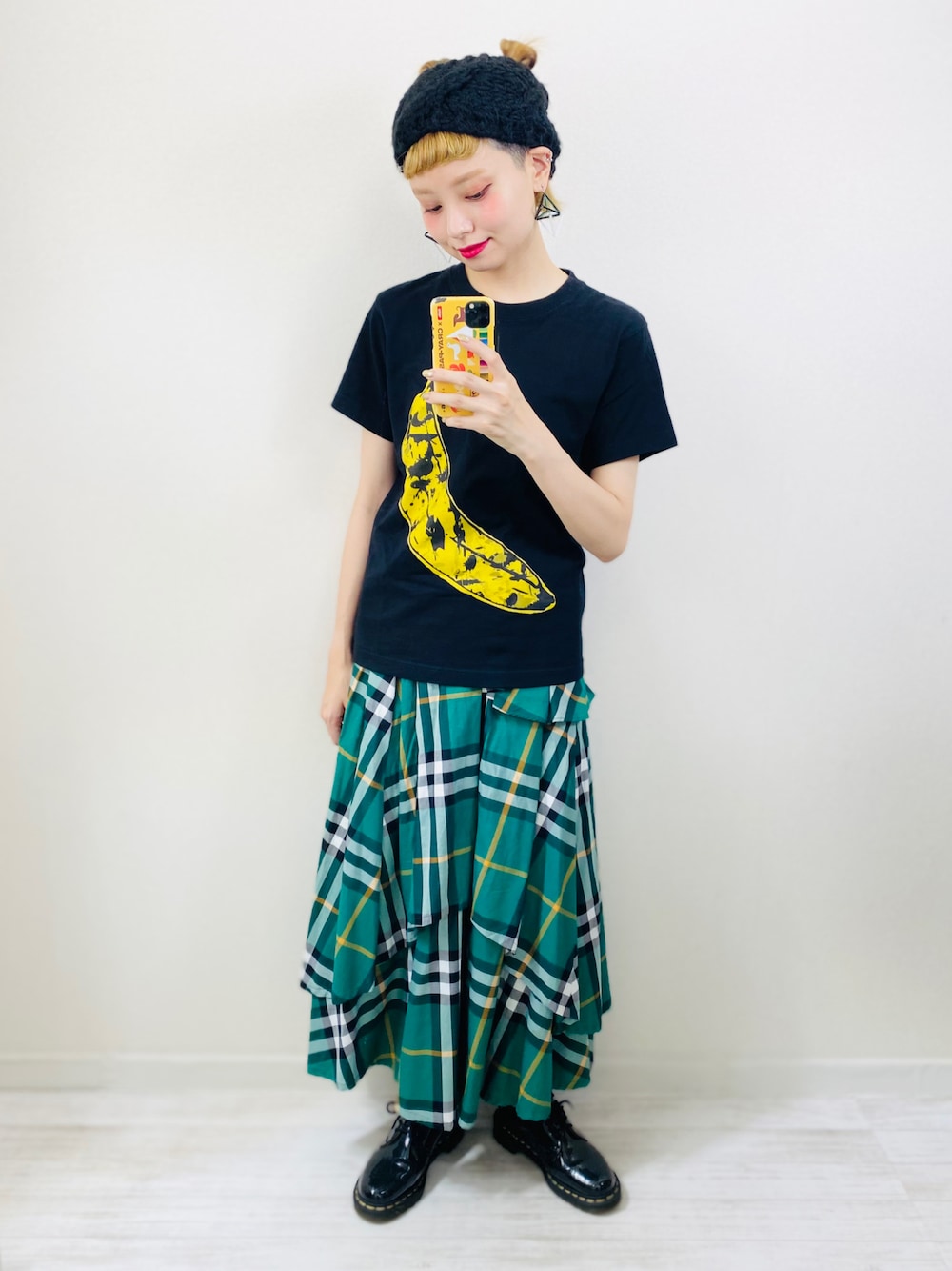 グリーン系のスカート、ブラック系のローファー、ブラック系のヘアバンドを着用したレディースの秋コーディネートの1枚目の写真