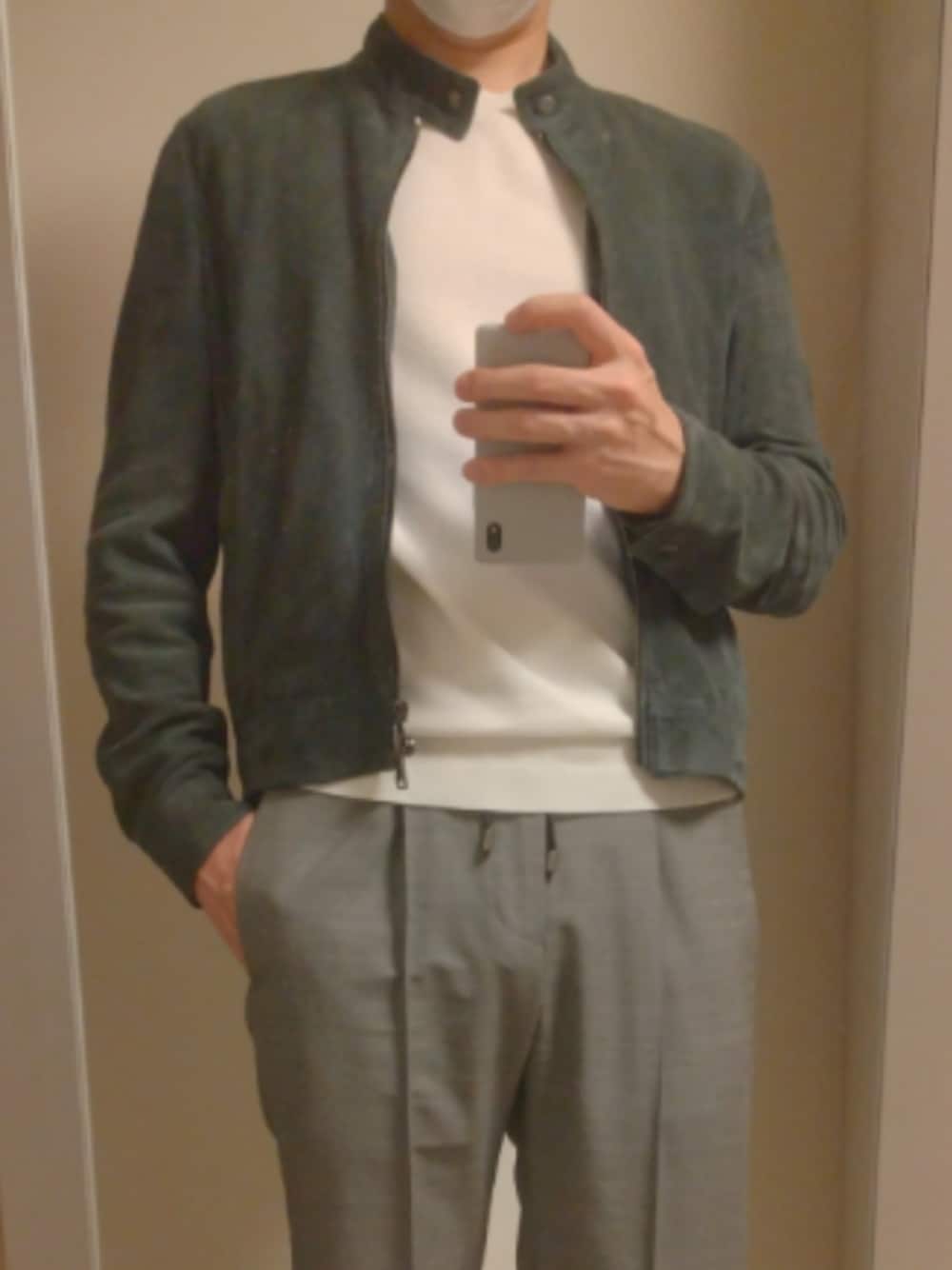 グレー系のスラックス、ブルー系のライダースジャケット、ホワイト系のニット/セーターを着用したメンズの秋コーディネートの1枚目の写真