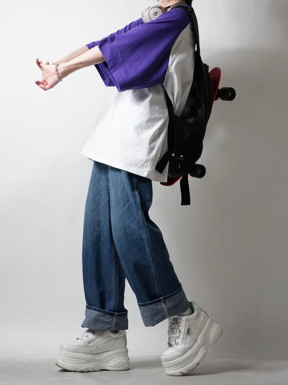 ブルー系のデニムパンツ、ホワイト系のスニーカー、パープル系のTシャツ/カットソーを着用したメンズの春コーディネートの1枚目の写真