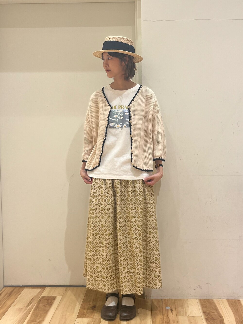 ホワイト系のTシャツ/カットソー、ホワイト系のカーディガン/ボレロ、ベージュ系のスカートを着用したレディースの春コーディネートの1枚目の写真