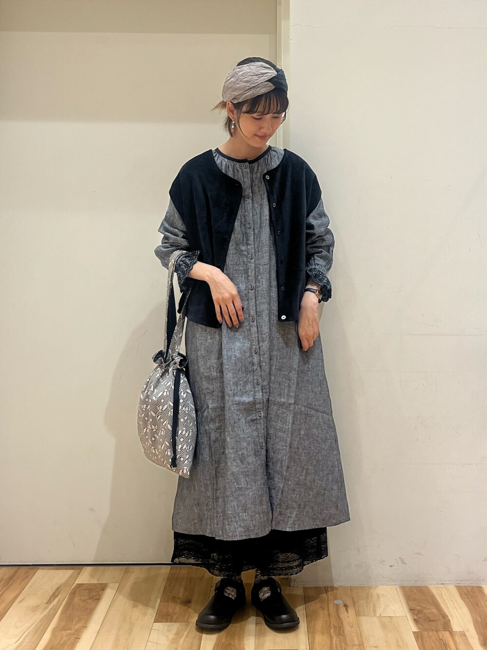 ブラック系のドレスシューズ、ブラック系のベスト、ブラック系のハンドバッグを着用したレディースの秋コーディネートの1枚目の写真