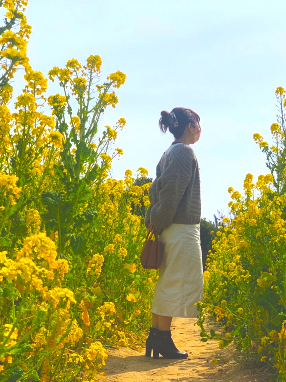 ブラウン系のカーディガン/ボレロ、ホワイト系のサロペット/オーバーオール、ブラウン系のブーツを着用したレディースの春コーディネートの1枚目の写真