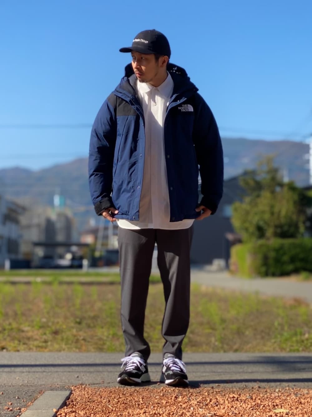 ホワイト系のシャツ/ブラウス、ブルー系のダウンジャケット/コート、グレー系のその他パンツを着用したメンズの秋コーディネートの1枚目の写真