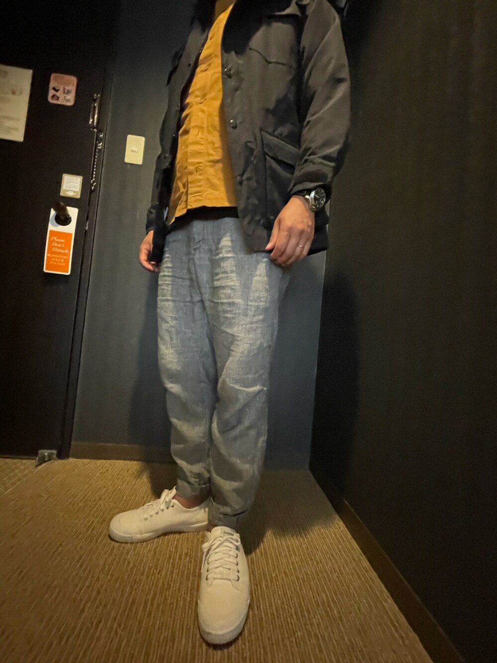 ブラック系のマウンテンパーカー、シルバー系のパンツ、ホワイト系のスニーカーを着用したメンズの春コーディネートの1枚目の写真