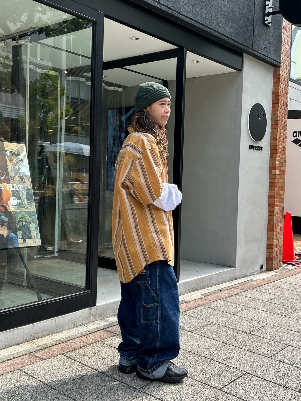 イエロー系のシャツ/ブラウス、ブルー系のデニムパンツ、ブラック系のスニーカーを着用したレディースの秋コーディネートの1枚目の写真