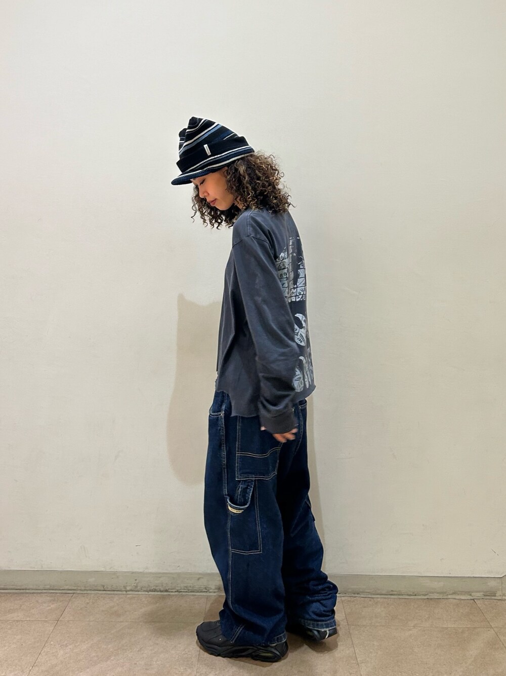 ブラック系のTシャツ/カットソー、ブルー系のデニムパンツ、ブラック系のスニーカーを着用したレディースの夏コーディネートの1枚目の写真