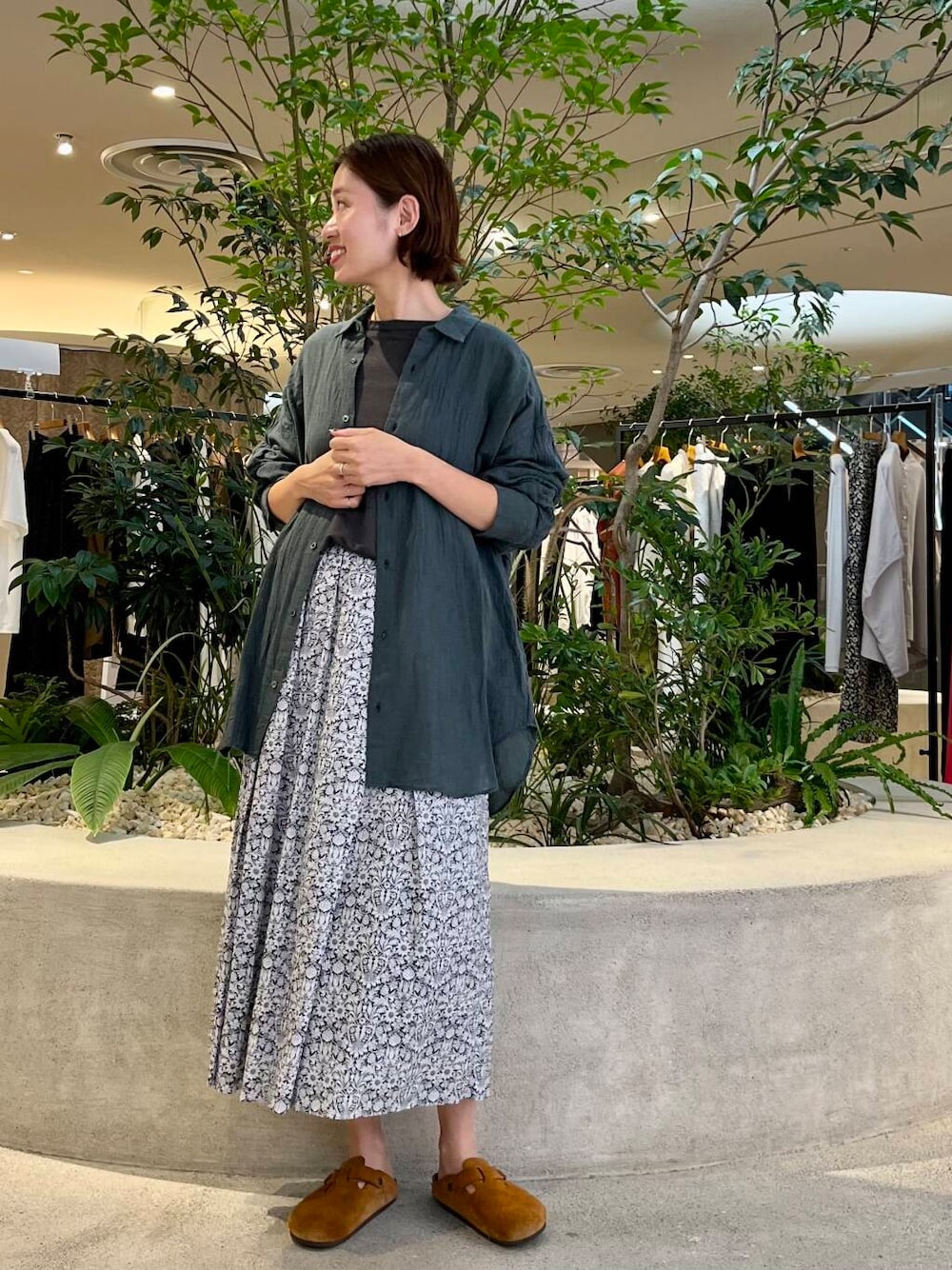 グレー系のTシャツ/カットソー、グリーン系のシャツ/ブラウス、ブラック系のスカートを着用したレディースの夏コーディネートの1枚目の写真