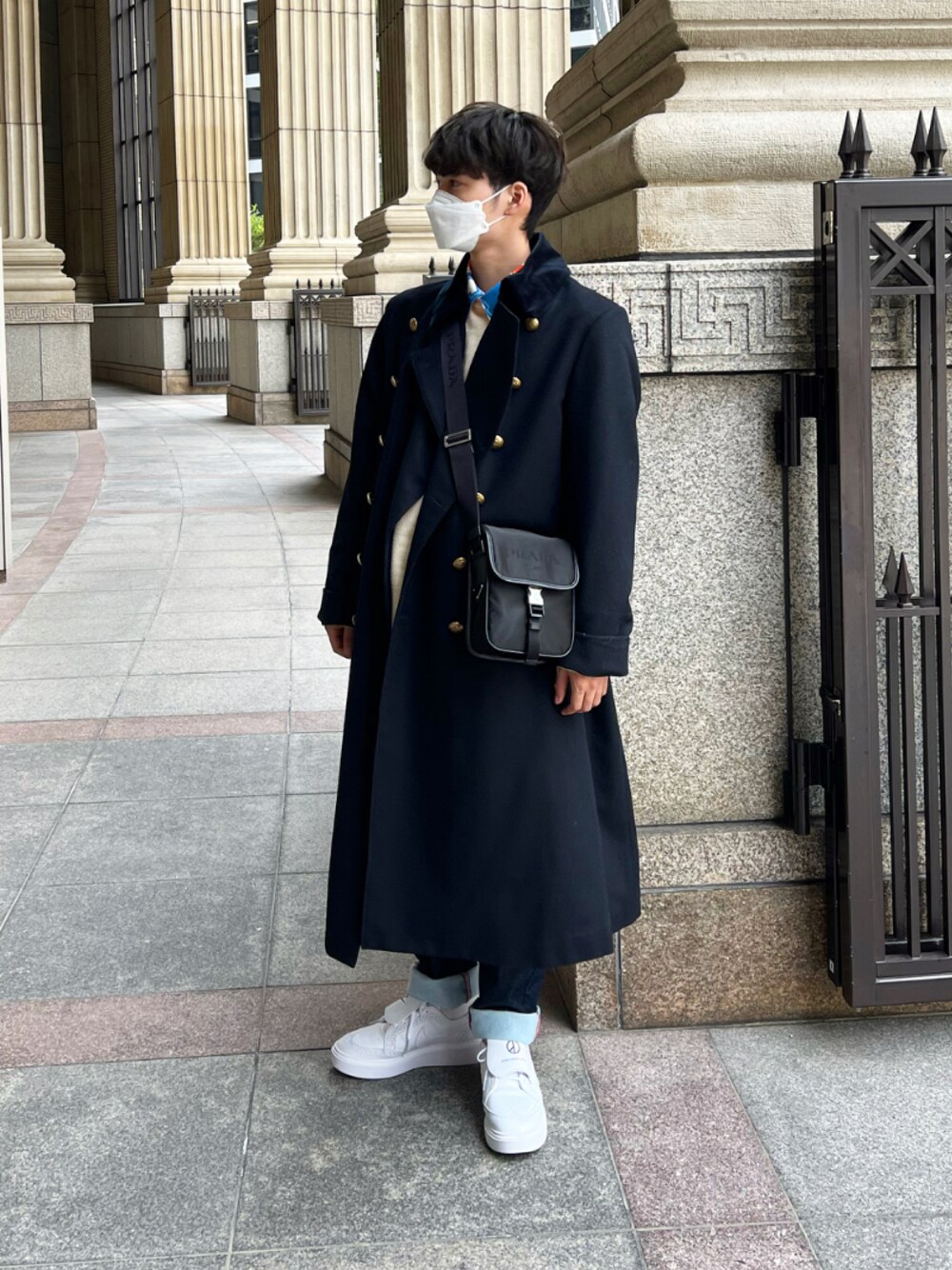 ブラック系のトレンチコート、ホワイト系のニット/セーターを着用したメンズの冬コーディネートの1枚目の写真