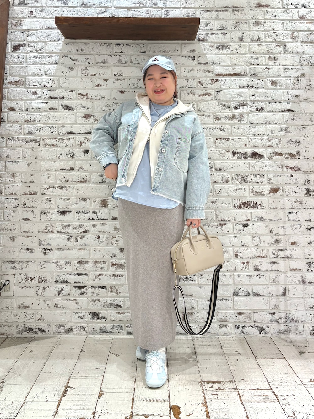 ホワイト系のパーカー、ブルー系のシャツ/ブラウス、グレー系のスカートを着用したレディースの冬コーディネートの1枚目の写真