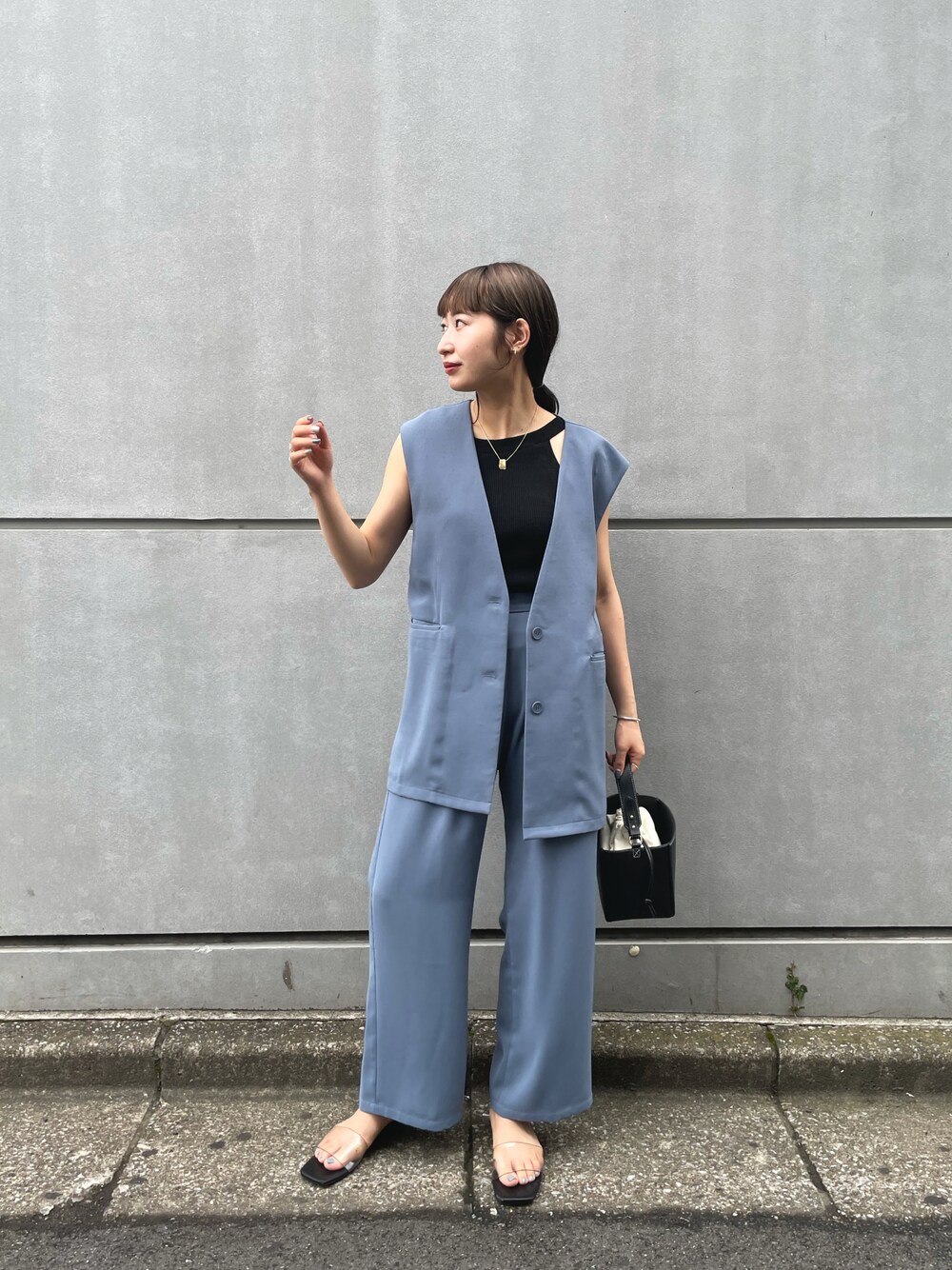 ブラック系のニット/セーター、ブルー系のベスト、ブルー系のスラックスを着用したレディースの夏コーディネートの1枚目の写真