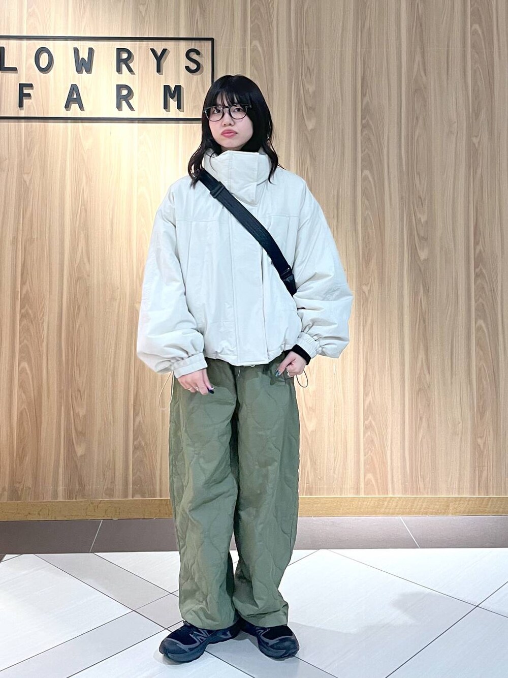 グリーン系のその他パンツ、ホワイト系のその他アウター、ブラック系のショルダーバッグを着用したレディースの冬コーディネートの1枚目の写真