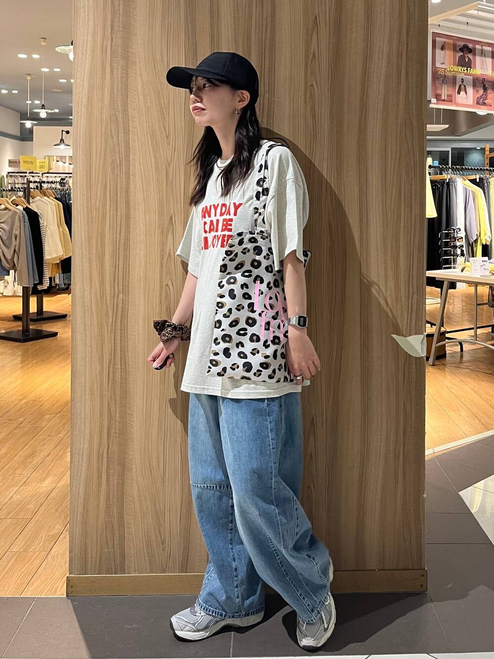 ブルー系のデニムパンツ、ホワイト系のTシャツ/カットソー、ブラック系のキャップを着用したレディースの春コーディネートの1枚目の写真