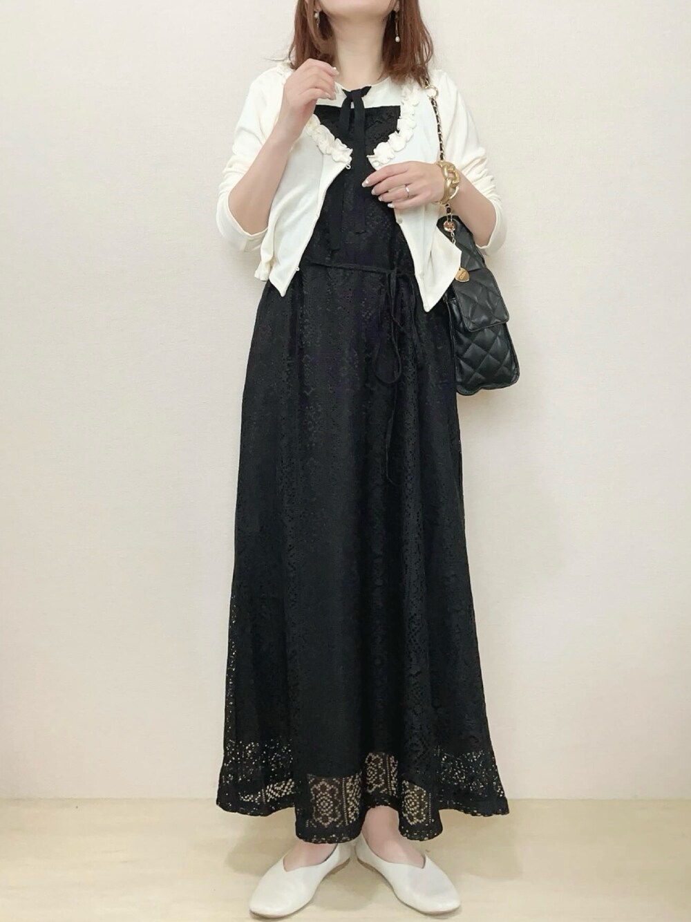 ブラック系のワンピース、ブラック系のショルダーバッグを着用したレディースの春コーディネートの1枚目の写真