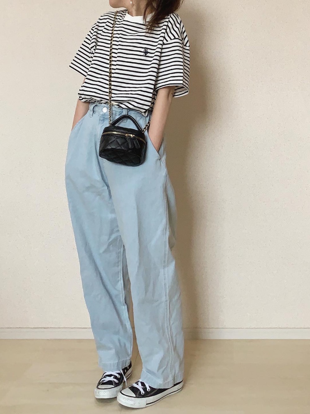 ブルー系のデニムパンツ、ホワイト系のTシャツ/カットソー、ブラック系のスニーカーを着用したレディースの春コーディネートの1枚目の写真