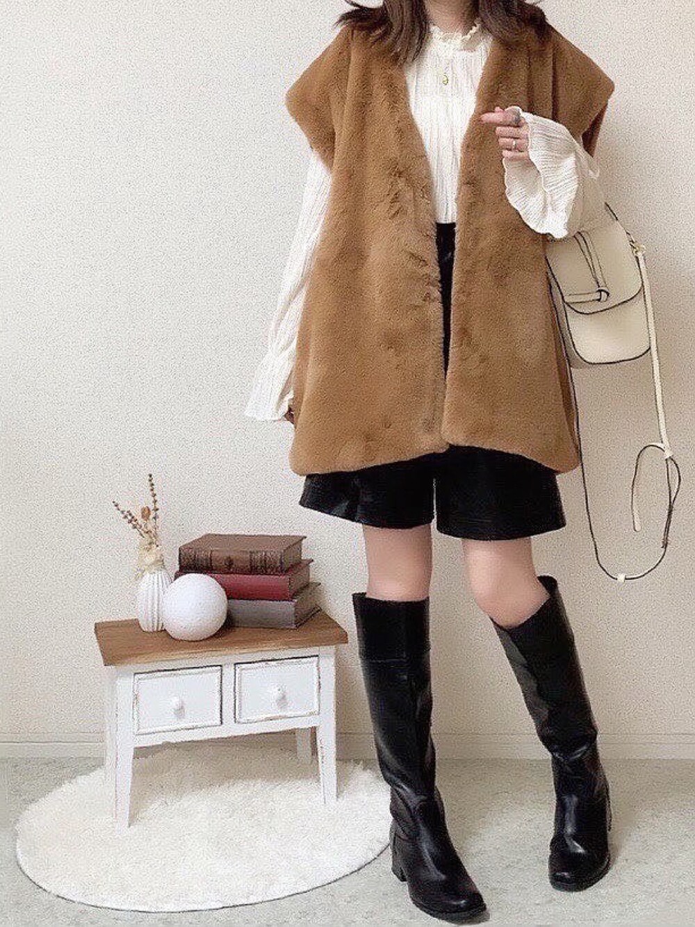 ブラウン系のベスト、ブラック系のその他パンツを着用したレディースの秋コーディネートの1枚目の写真